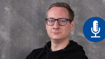 Porträt eines Mannes mit Brille vor grauem Hintergrund; rechts daneben befindet sich ein blaues Symbol mit einem stilisierten Mikrofon, das für Podcast steht.