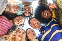 A diverse group of people put their hands over each other with motivation.